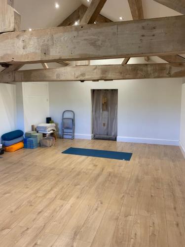 The Gannah Farm Shepherds Hut في هيريفورد: غرفة فارغة مع أرضية خشبية وسقف خشبي