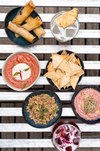 a table topped with different types of food and dips at Hôtel Rosalie in Paris