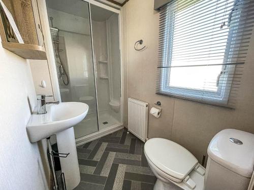 ein Bad mit einem WC, einem Waschbecken und einer Dusche in der Unterkunft Beautiful 6 Berth Caravan At Breydon Water Nearby Great Yarmouth Ref 10056b in Belton