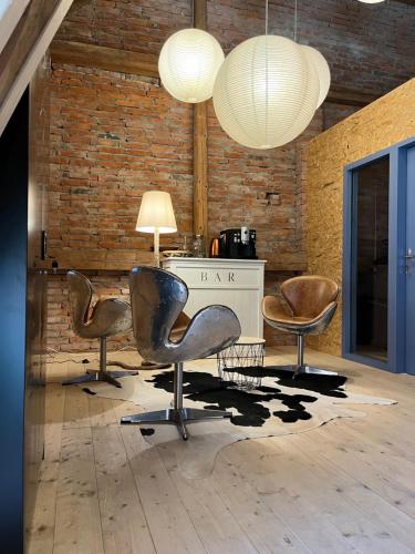 a room with three chairs and a desk and two lamps at BÜR in Büren an der Aare