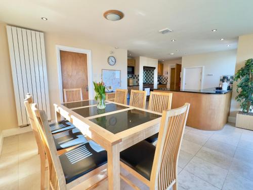 a dining room with a wooden table and chairs at Pendennis in Padstow