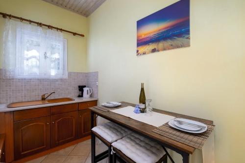 a kitchen with a sink and a table with plates on it at Ranias Case Dell Olivetto in Gaios