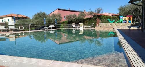a large swimming pool with blue water in a yard at Campeggio Gianna Golfo dei Poeti in Lerici