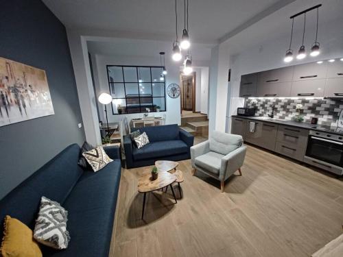un soggiorno con divano e sedie blu e una cucina di HOME Sweet HOME a Mytilini