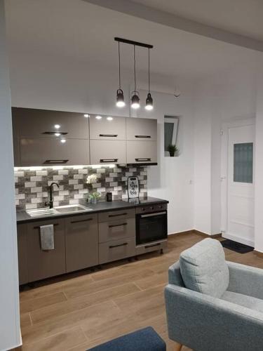 a living room with a kitchen and a couch at HOME Sweet HOME in Mytilini