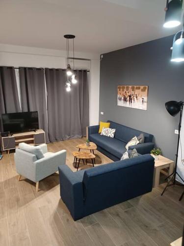 a living room with a blue couch and chairs at HOME Sweet HOME in Mytilini
