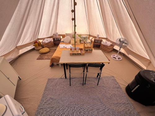 a room with a table and chairs in a tent at Glamping Bieszczady z jacuzzi i basenem in Solina