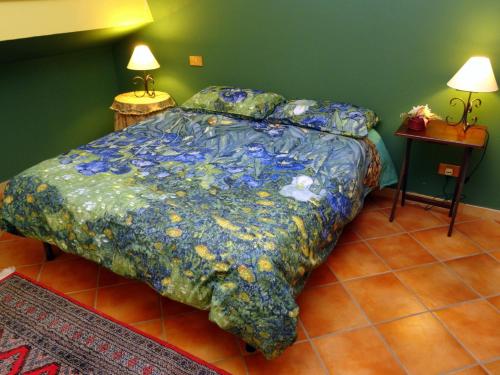 - un lit avec une couette colorée dans une chambre dans l'établissement BB DoliaHouse, à Dolianova