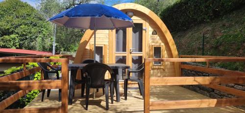 einen Tisch und Stühle mit einem Sonnenschirm auf einer Terrasse in der Unterkunft Campeggio Gianna Golfo dei Poeti in Lerici