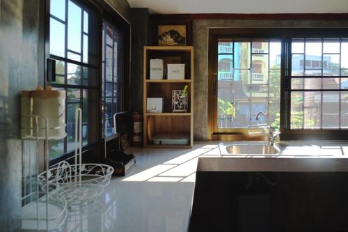 a kitchen with a sink and some windows at GrandmaD in Chiang Rai