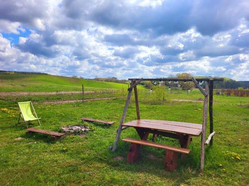 a picnic table and a chair in a field at Dom Malarki in Mirosławiec