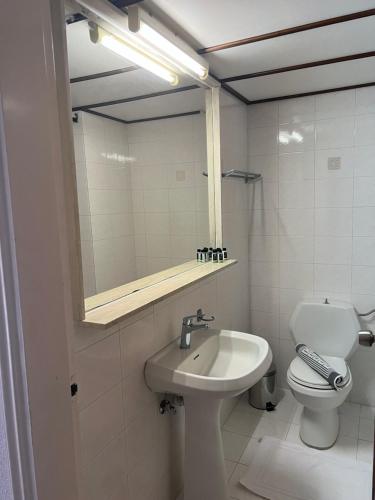 a bathroom with a sink and a toilet and a mirror at Smart Accommodation Rhodes in Rhodes Town