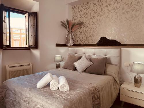 een slaapkamer met een bed met witte handdoeken bij Apartamento Moctezuma in Ronda