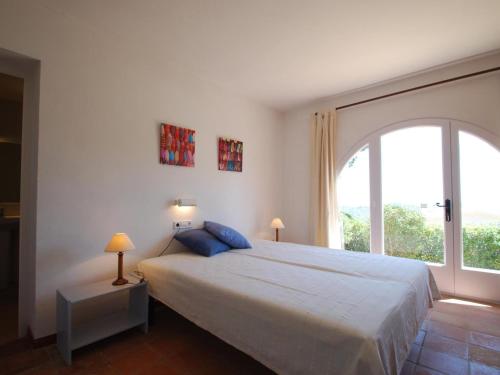 a bedroom with a large bed and a large window at Pinetells in Begur