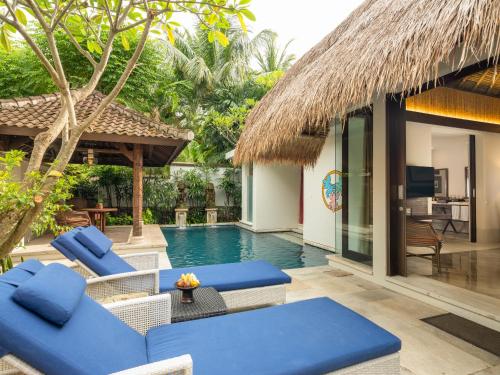 a resort with a swimming pool with blue chairs at Sudamala Resort, Senggigi, Lombok in Senggigi 