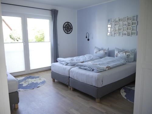 1 Schlafzimmer mit 2 Betten und einem großen Fenster in der Unterkunft Ferienhaus Haffliebe in Scharbeutz