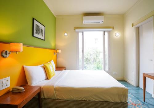 a bedroom with a bed with yellow and green walls at Bloom Boutique l Signature Towers in Gurgaon