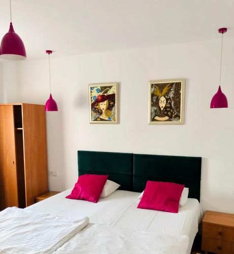 a bedroom with a bed with two red pillows at Viking in Dziwnów