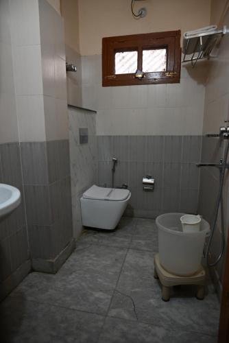 a bathroom with a tub and a toilet and a sink at Hotel Atul Regency in Rāmpur