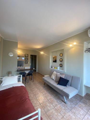 Aggelou Apartments في سباتا: غرفة معيشة مع أريكة بيضاء وطاولة