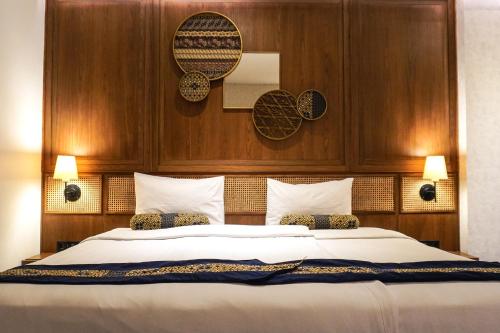 a bedroom with a large bed with a wooden headboard at de JAVA Hotel Bandung in Bandung