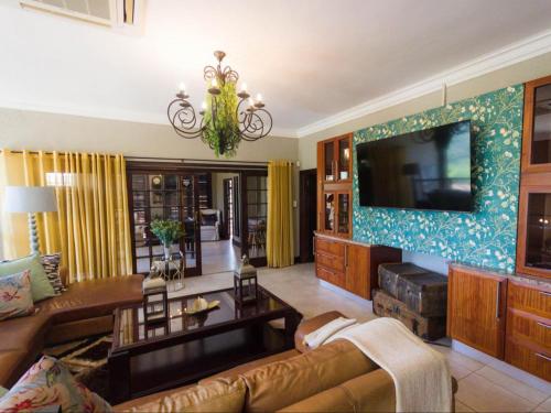 a living room with a couch and a tv at The Castello at Kruger in Marloth Park
