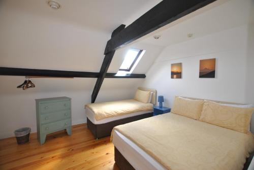 um quarto com uma cama, uma cadeira e uma janela em The Arch An Capall Dubh Dingle em Dingle