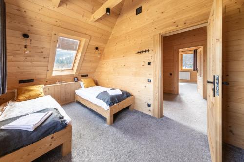 a bedroom with two beds in a log cabin at Domek Przy Dolinie in Kościelisko