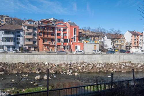 a river with buildings in the background of a city at Апартамент Орловска in Gabrovo