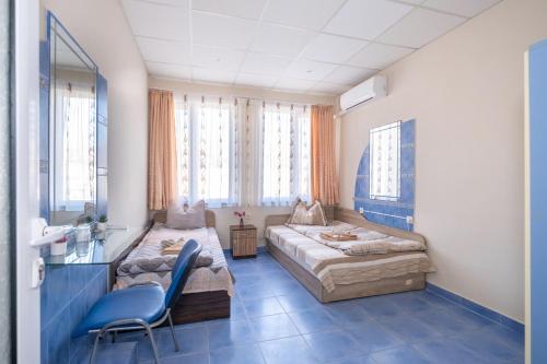 een kamer met 2 bedden en een stoel. bij Апартамент Орловска in Gabrovo