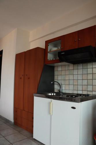 a kitchen with a sink and a stove and cabinets at Dream apartments limnionas in Limniónas