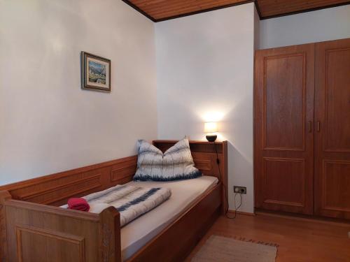 a small bedroom with a bed with a wooden frame at Pension Welserhof in Wilfersdorf