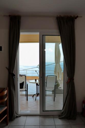 a sliding glass door with a view of the ocean at Dream apartments limnionas in Limniónas