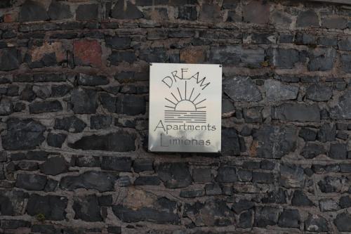 a sign on the side of a brick wall at Dream apartments limnionas in Limniónas