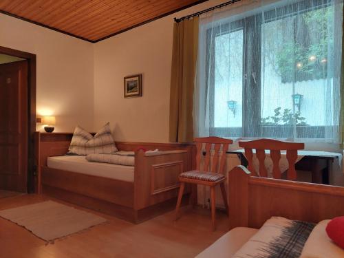 a bedroom with a bed and a table and a window at Pension Welserhof in Wilfersdorf