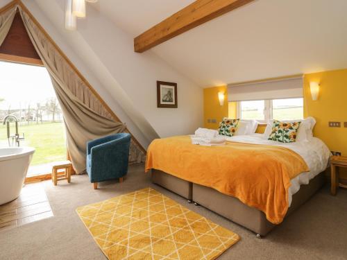 - une chambre avec un lit, une baignoire et un lavabo dans l'établissement Bluebell Cottage, à Ulverston