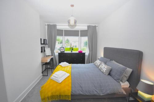 愛丁堡的住宿－The Grove，一间卧室配有一张床、一张书桌和一个窗户。