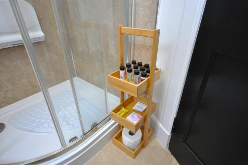 une douche avec une étagère en bois à côté d'une cabine de douche dans l'établissement The Grove, à Édimbourg
