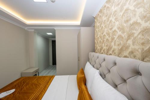 a bedroom with a white bed and a wall at SKYSTAR DELUXE HOTEL in Istanbul