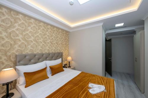 a bedroom with a large bed with orange pillows at SKYSTAR DELUXE HOTEL in Istanbul