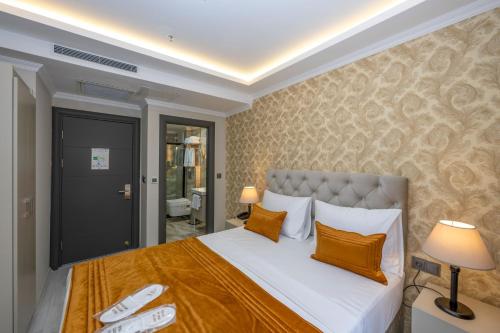 a bedroom with a bed with white sheets and orange pillows at SKYSTAR DELUXE HOTEL in Istanbul