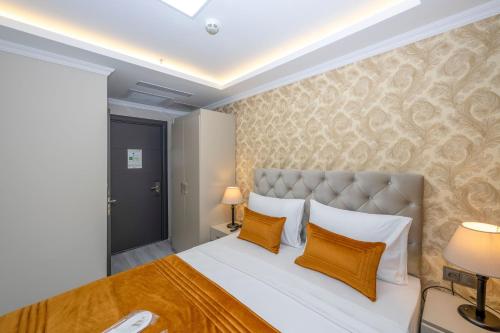 a bedroom with a large bed with orange pillows at SKYSTAR DELUXE HOTEL in Istanbul