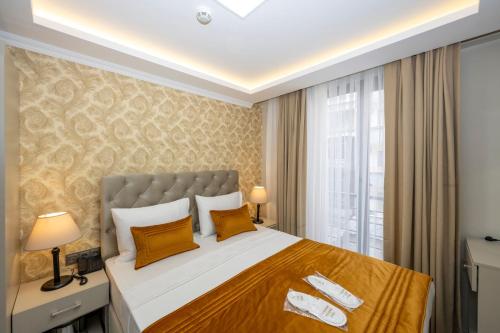 a bedroom with a large bed with yellow pillows at SKYSTAR DELUXE HOTEL in Istanbul