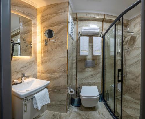 a bathroom with a sink and a toilet and a shower at SKYSTAR DELUXE HOTEL in Istanbul