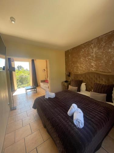 a bedroom with a large bed with two towels on it at Hôtel de La Fossette in Le Lavandou