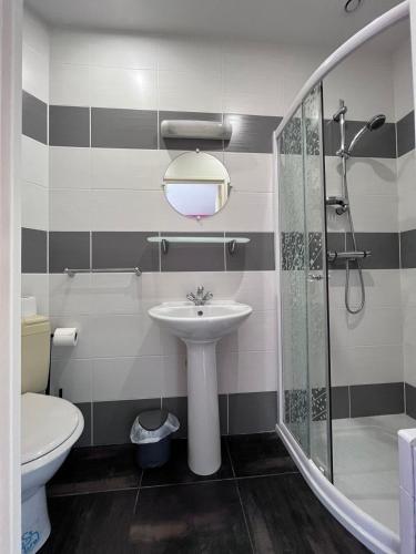 a bathroom with a sink and a shower and a toilet at Villa de l’Eguille in LʼÉguille