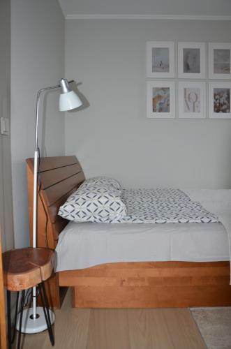 a bedroom with a bed with a lamp and a chair at Panoramic Apt in the City center in Palanga