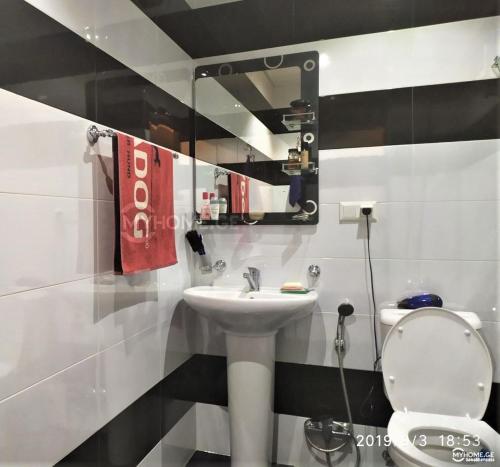 a bathroom with a sink and a toilet and a mirror at Izi's cozy apartment in Kutaisi