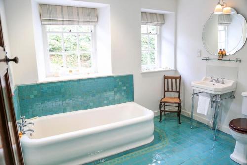 a bathroom with a bath tub and a sink at Wolford Lodge Traditional home surrounded 150 private acres with Tennis court in Honiton