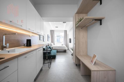 a kitchen with white cabinets and a table and a bed at Pantheon, Nilie Hospitality MGMT in Thessaloniki
